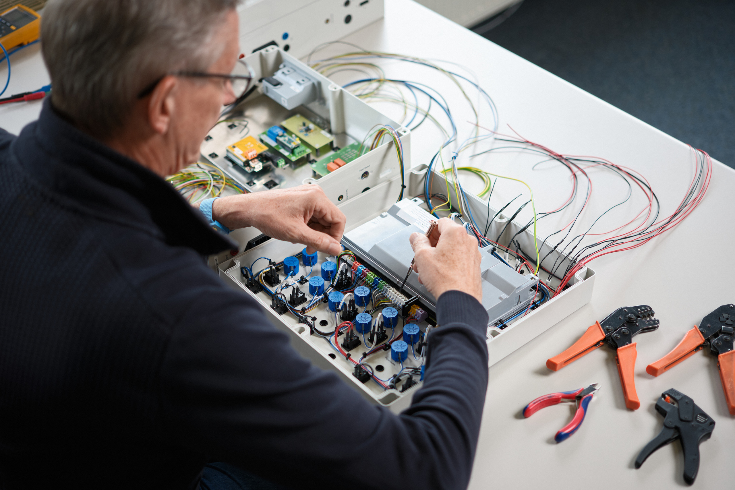 The hero image for the topic automatic industrial test equipment solutions shows one of our engineers working on an inspection device.